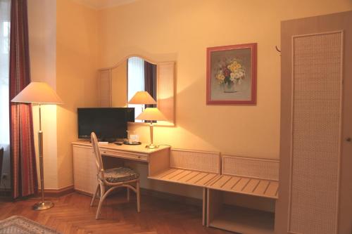 Cette chambre comprend un bureau avec un ordinateur et une chaise. dans l'établissement Pension Villa Beer, à Stralsund