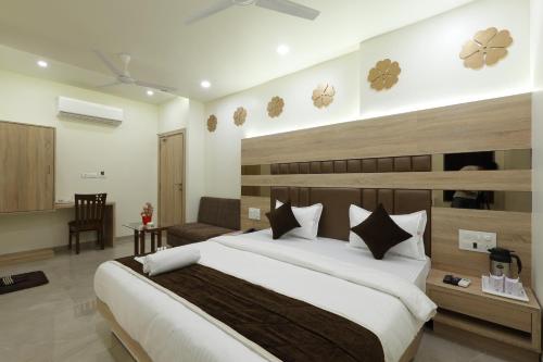 a bedroom with a large bed and a couch at Hotel Alka Inn in Ahmedabad