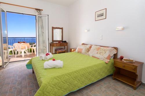 a bedroom with a green bed and a balcony at Summer Dream in Vlachata