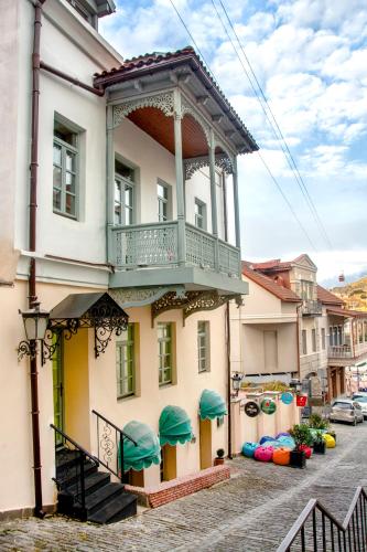 a building with a balcony on a street at Maison Boutique Hotel in Tbilisi City