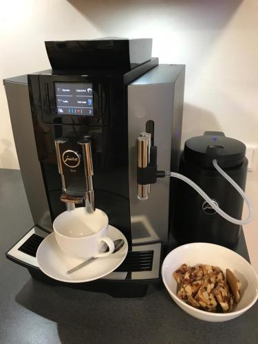 een koffiezetapparaat met een kopje en een kom eten bij Antonius Hoeve in Oudenbosch