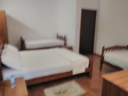 a room with two beds in a room with a table at The Rock House in Katunayake