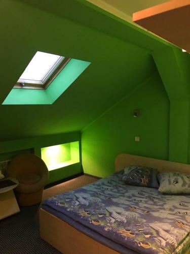 a green room with a bed and a skylight at Premier Club in Chernivtsi