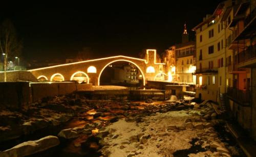 a city street at night with a bridge and snow at Apartaments Can Bundanci in Setcases