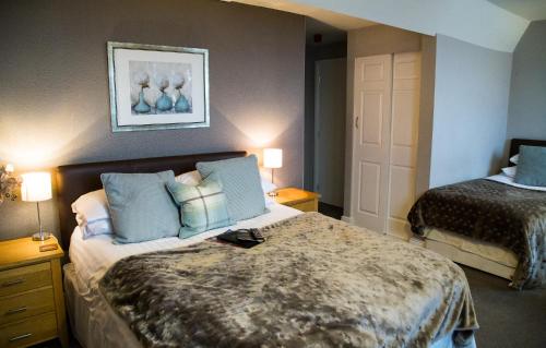 a hotel room with two beds with blue pillows at Hedley House Hotel & Apartments in York