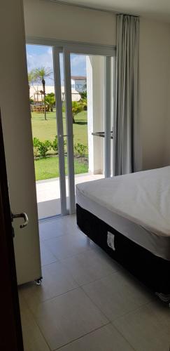 a bedroom with a bed and a view of the ocean at Apartamento 3 Quartos Tree Bies Resort Subauma in Subaúma