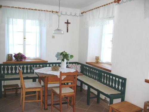a dining room with a table and benches and windows at Beim Schachnerhaus in Pöllauberg