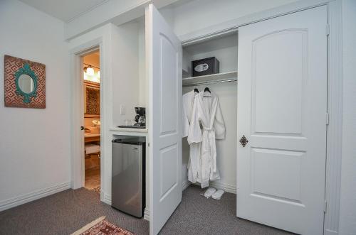 a walk in closet with a white robe and a door at Houston Towers Inn, Adults-Only, Downtown, Med Ctr, NRG in Houston