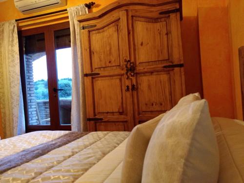 a bedroom with a bed and a wooden cabinet at El Mirador De Ruidera in Ruidera
