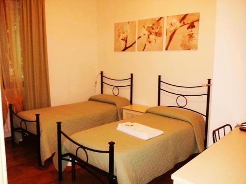 a hotel room with two beds and a table at Luconi Affittacamere in Iesi