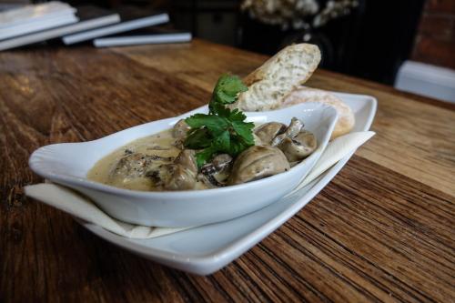 a bowl of food with mushrooms and bread on a table at Hedley House Hotel & Apartments in York