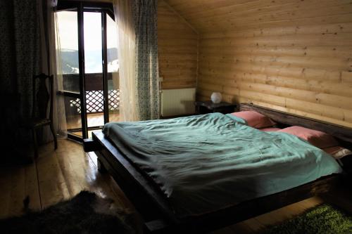 Cama en habitación de madera con ventana en Private Cottage 375 en Bukovel
