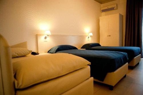 a hotel room with two beds with blue sheets at Hotel La Terrazza in Barletta