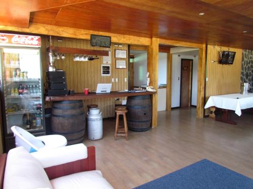 a bar in a room with wooden walls and wooden floors at Hostería Antupirén in Hornopiren