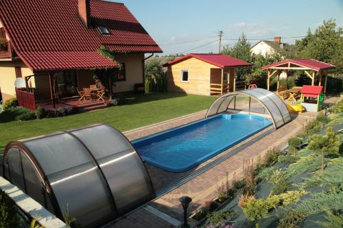 a swimming pool in a yard next to a house at Noclegi Na Bukowym Stoku in Czaniec