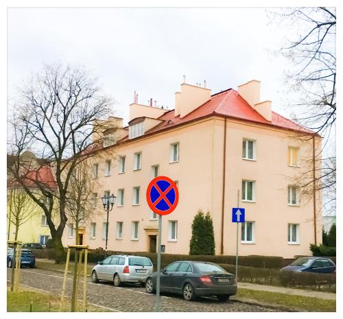 a street sign in front of a building with parked cars at Apartament Katarzynka Stare Miasto in Toruń