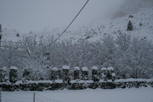 a fence covered in snow in front of a mountain at Casas Rurales Los Enebros Nerpio in Nerpio
