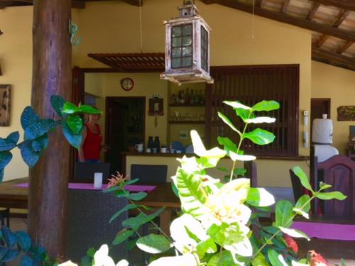 a room with a table and a woman in a kitchen at Bahiadomizil in Canavieiras