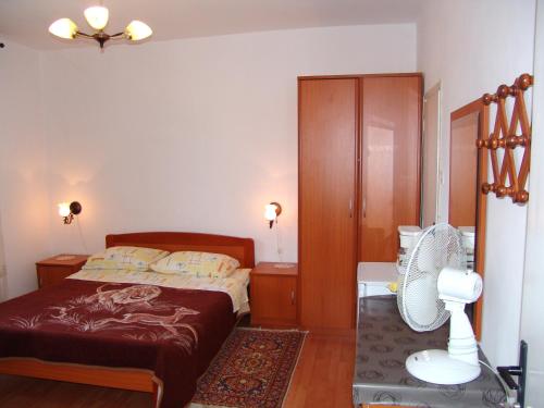 a bedroom with a bed and a fan at Sobe Bozica in Krk