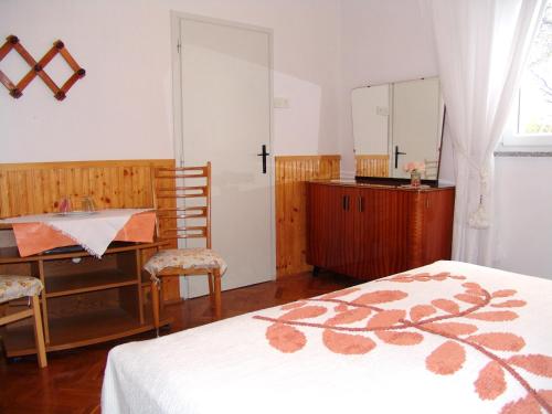 a bedroom with a bed and a desk and a mirror at Sobe Bozica in Krk