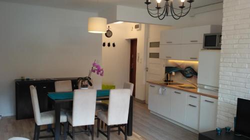 - une cuisine et une salle à manger avec une table et des chaises dans l'établissement Apartament Turkusowy, à Szczecin