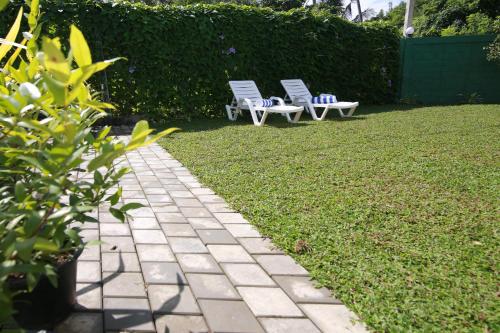 two chairs sitting on a lawn in a yard at Athithi Villa in Hikkaduwa