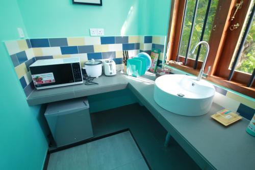 a bathroom counter with a sink and a window at Athithi Villa in Hikkaduwa