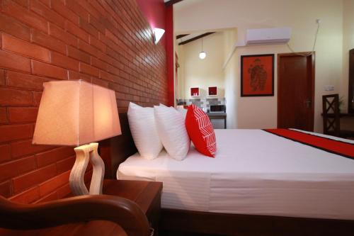 a bedroom with a bed with a red brick wall at Athithi Villa in Hikkaduwa