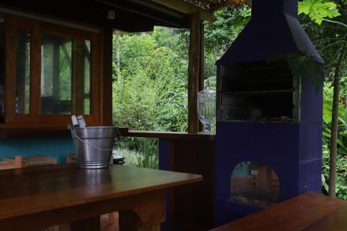 a wood fired oven in a kitchen with a table at Casa Ka in Maresias