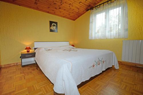 een slaapkamer met een wit bed en een raam bij Apartmani KRAMAR in Poreč