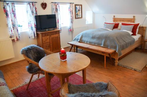a bedroom with a bed and a table and a tv at Landlust Ischl in Bad Ischl