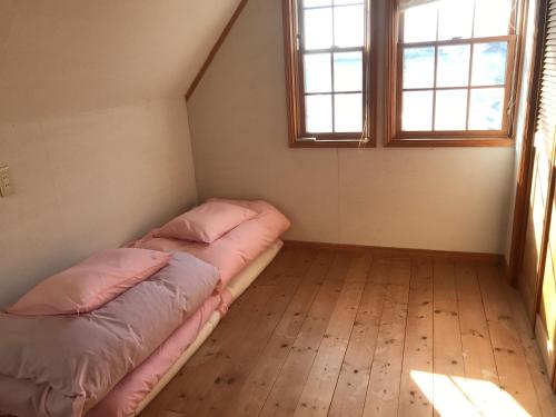 a bedroom with two beds and two windows at Guesthouse Irago in Tahara