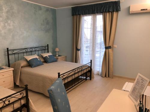 una camera da letto con un letto con cuscini blu e una finestra di Maison Bijou B&B ad Avola