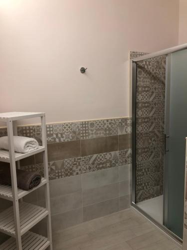 un bagno con doccia con porta in vetro di Maison Bijou B&B ad Avola