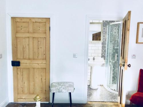 a bathroom with a wooden door and a sink at Causeway Coast Townhouse in Ballycastle