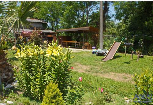 een achtertuin met een speeltuin met een glijbaan en een park bij Ararat House in Tsandrypsj