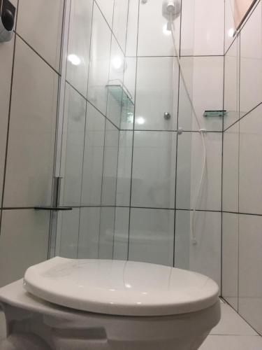 a bathroom with a toilet and a glass shower at Loft Centro in Arraial do Cabo