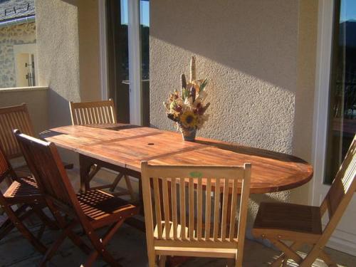 a wooden table with chairs and a vase of flowers on it at Le Calmadou in Formiguères