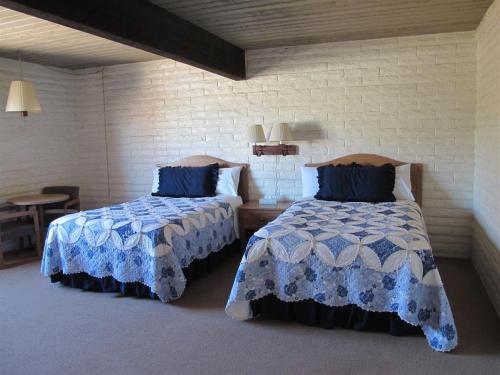 a bedroom with two beds with blue and white sheets at Stage Stop Inn in Patagonia