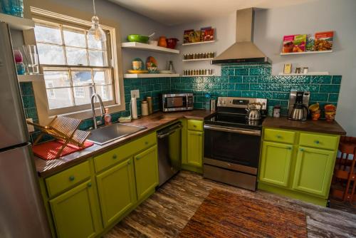 a kitchen with green cabinets and a sink at BohoPad in Charlotte