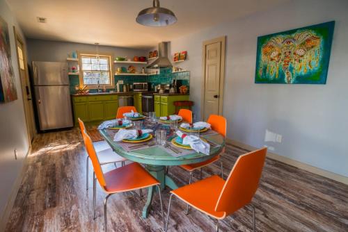 a kitchen with a table and orange chairs in a room at BohoPad in Charlotte