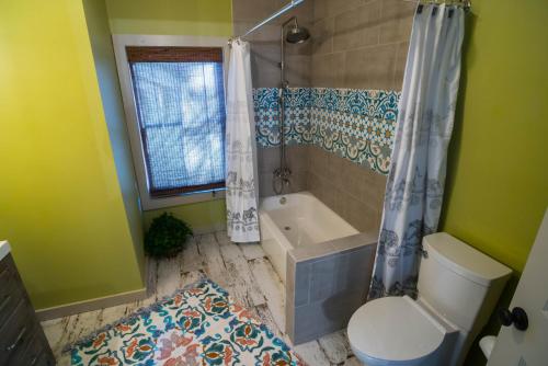 a bathroom with a tub and a toilet and a shower at BohoPad in Charlotte