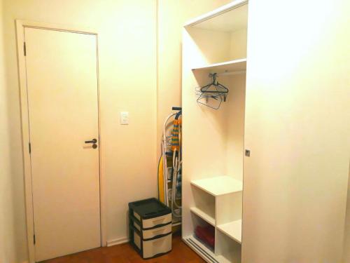 a closet with a door and some boxes in it at Apartamento Pé na Areia em Santos in Santos