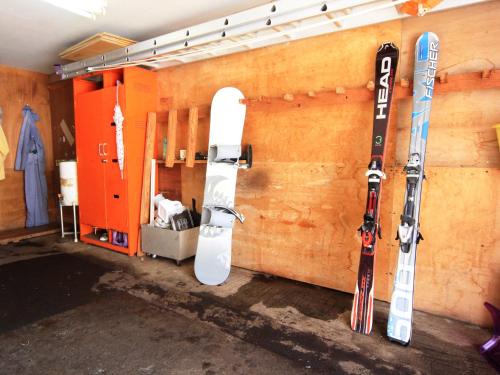 una habitación con esquís y tablas de snowboard colgadas en una pared en Pension Himawari en Iizuna