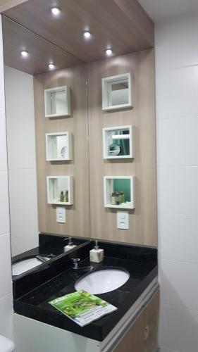 a bathroom with a sink and a mirror at Le Bon Vivant 108 in Arraial do Cabo