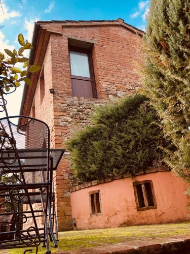 a building with a bush growing on the side of it at Agriturismo Casa VolaterrA in Volterra