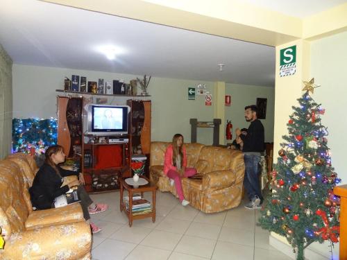 a group of people in a living room with a christmas tree at Kantu Hospedaje in Cusco