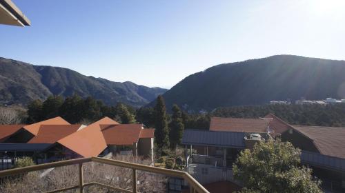 a group of buildings with mountains in the background at Hakone Forest of Verde in Hakone