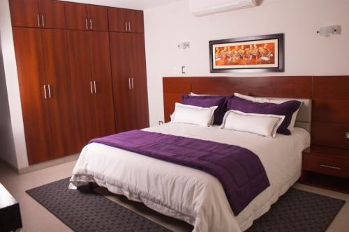 a bedroom with a large bed and wooden cabinets at Sunec Hotel in Chiclayo
