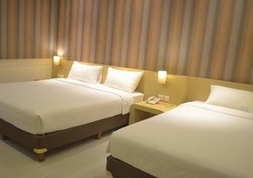 a hotel room with two beds and a telephone at Sweet Garden Guest House in Malang